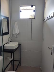 La salle de bains est pourvue d'un lavabo et d'une douche. dans l'établissement Maga hospedagem, à Penha