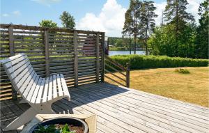 a white bench sitting on a wooden deck with a fence at Cozy Home In Sexdrega With Lake View in Sexdrega