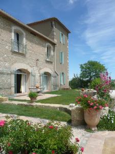 una casa grande con flores delante en La Bergerie de l'etang, en Montels