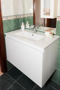 Baño blanco con lavabo y espejo en VelayLi - Apartamento en el centro de Finisterre, en Finisterre