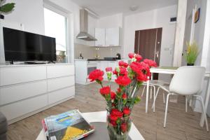a kitchen with a vase with red flowers on a table at Wczasowa in Warsaw