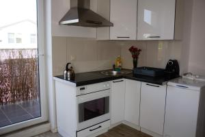 a small kitchen with white cabinets and a sink at Wczasowa in Warsaw