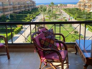 a balcony with a chair and a view of a street at Blumar North Coast in El Alamein