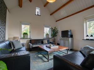uma sala de estar com mobiliário de couro e uma mesa de centro em Hemels Helleke em Oosterhout