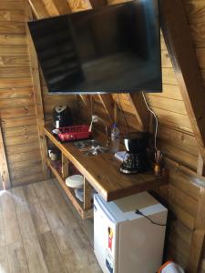 a kitchen with a sink and a tv in a cabin at RECANTO VERDES VALES in Palhoça