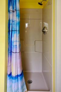 y baño con ducha y cortina de ducha colorida. en Dock House Inn, en Old Orchard Beach