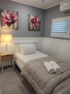 1 dormitorio con 1 cama con 2 toallas en Cozy Bedroom with Ensuite - Amazing City Location en Townsville