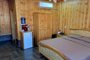 1 dormitorio con 1 cama y nevera pequeña en atoom lodge, en Jerash