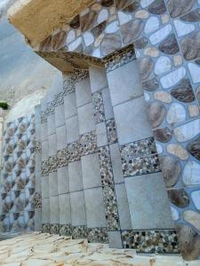 un edificio con una pared de piedra con rocas. en atoom lodge, en Jerash