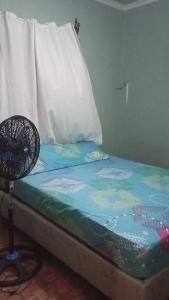 a bed with a fan sitting on top of it at Casa hotel Aguas Termales in Gracias