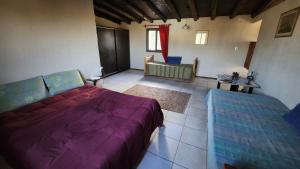a bedroom with a bed and a couch in a room at Kairos Cabañas in Las Compuertas
