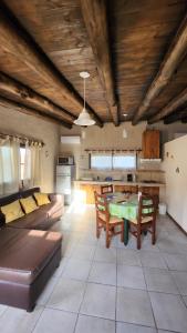 a living room with a table and a kitchen at Kairos Cabañas in Las Compuertas