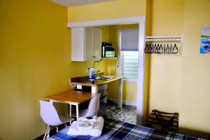 una pequeña cocina con paredes amarillas, mesa y sillas en Dock House Inn, en Old Orchard Beach