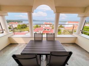 a table and chairs on a balcony with a view of the water at Villa Livi - Luxury sea view appartments in Medulin