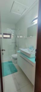 a white bathroom with a sink and a toilet at Vintage House by the Sea in Chorefto +51 photos