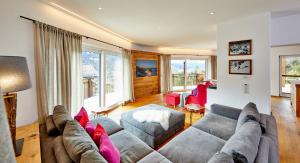 a living room with a gray couch and pink pillows at Das Gsteig in Garmisch-Partenkirchen