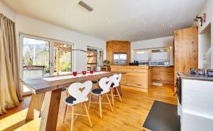 a kitchen with a large wooden table and chairs at Das Gsteig in Garmisch-Partenkirchen