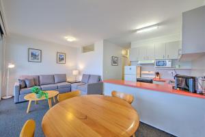 a living room with a wooden table and a kitchen at Snow Ski Apartments 19 in Falls Creek