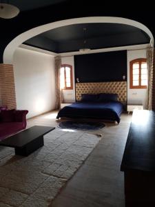 Un dormitorio con una cama y una mesa. en Très belle villa familiale et romantique/SPA, en Agadir