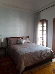 1 dormitorio con 1 cama grande y ventana en Très belle villa familiale et romantique/SPA, en Agadir