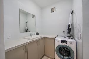 a white bathroom with a washing machine and a sink at Snow Ski Apartments 25 in Falls Creek