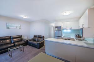 a living room with a couch and a kitchen at Snow Ski Apartments 25 in Falls Creek