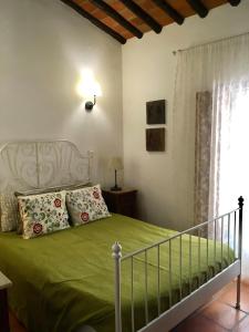 a bedroom with a bed with green sheets and a window at Quinta da Trombeta in Borba +43 photos