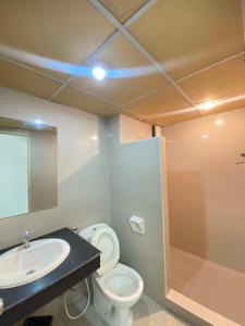 uma casa de banho com um WC, um lavatório e um espelho. em PDA Lord Hotel em Bangkok