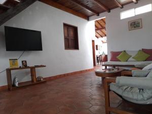 sala de estar con TV de pantalla plana en la pared en La Morada Hospedaje en Barichara