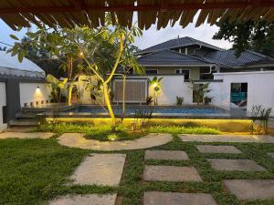 a house with a tree in the middle of a walkway at Villa Motel Mas Guesthouse in Batang Berjuntai