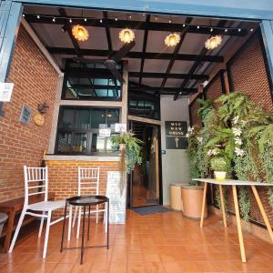 a patio with chairs and tables in front of a building at MEEMAW'S House Hostel in Bangkok