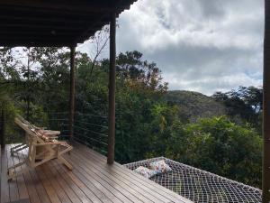 a wooden deck with a bench and a table on it at Alto da Villa Loft in Ouro Preto
