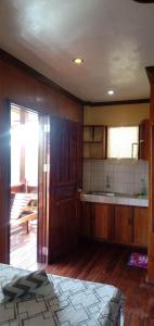 um quarto com uma cozinha com uma cama e um lavatório em Nellie's Tourist Inn- Port Barton em San Vicente
