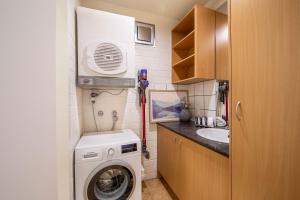 a small kitchen with a washing machine and a sink at Snow Ski Apartments 24 in Falls Creek