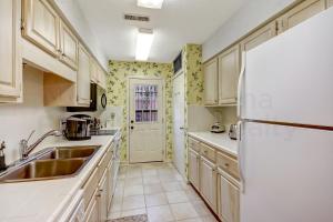 eine Küche mit einer Spüle und einem Kühlschrank in der Unterkunft Fairway Oaks Villa Condo in Amelia Island