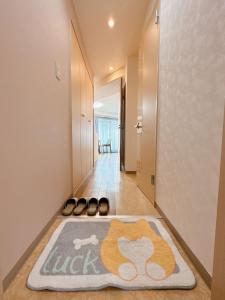a hallway with a rug on the floor and a pair of shoes at 三米-黒門市場-黑门市场-kuromon 202タイプ in Osaka
