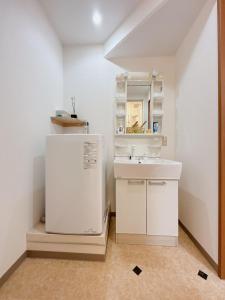 a white bathroom with a sink and a mirror at 三米-黒門市場-黑门市场-kuromon 202タイプ in Osaka