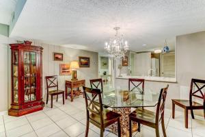 a dining room and kitchen with a glass table and chairs at Pool View Beachwood Condo in Fernandina Beach