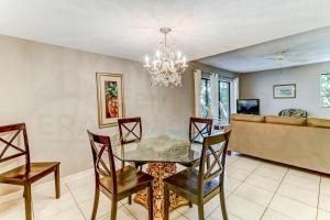 a dining room with a glass table and chairs at Pool View Beachwood Condo in Fernandina Beach
