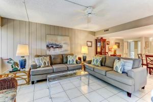 a living room with two couches and a table at Pool View Beachwood Condo in Fernandina Beach