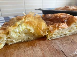 two pieces of pie sitting on a wooden cutting board at Heritage Home Ustikolina in Foča