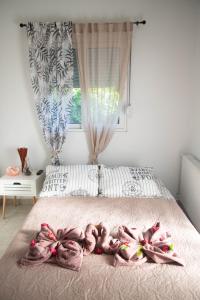 Livadi house في ثيولوغيس: غرفة نوم مع سرير وبطانيات وردية ونافذة