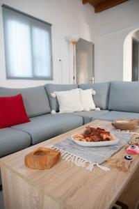 a living room with a couch and a table with a plate of food at Livadi house in Theologos