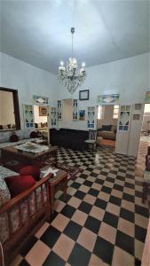 uma sala de estar com piso em xadrez e um lustre em Maison Familiale, vue sur mer à 5 minutes em Larache