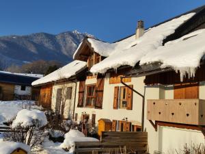 una casa ricoperta di neve con montagne sullo sfondo di Mansion in Albertville near Ski Slopes a Mercury