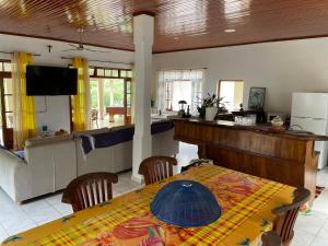 a dining room with a table and a kitchen at Villa Ura in Uturoa