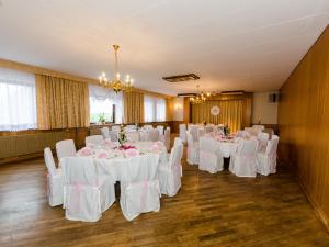 un salón de banquetes con mesas blancas y sillas blancas en Landhotel Hamburger Hof, en Nettlingen