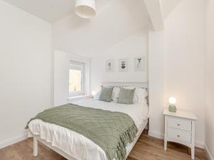 Dove Cottage في إينفيرنيس: غرفة نوم بيضاء بها سرير ونافذة