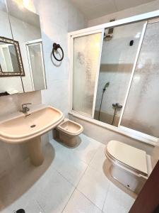 ein Bad mit einem Waschbecken, einem WC und einer Dusche in der Unterkunft Apartamento con Piscina 3 habitaciones in Sueca