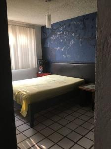 a bedroom with a bed with a blue wall at Departamento Rouge in Cuernavaca